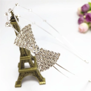 Détail du serre-tête avec nœud en strass argenté posé sur un modèle de tour Eiffel