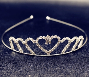Detail of silver heart-shaped tiara with sparkling rhinestones and central bow accent