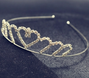 Detailed close-up of crystal heart crown headband with sparkling rhinestones on black