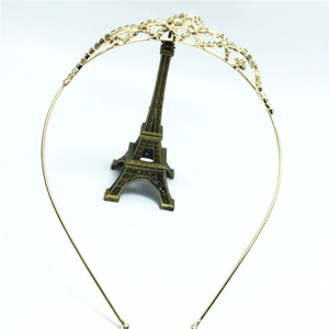 Detailed view of a gold-colored tiara headband featuring shimmering white rhinestones
