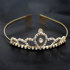 Détail du diadème doré avec strass en cœur sur fond de cuir noir texturé élégant