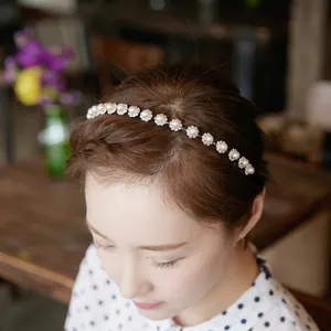 Elegant headband with faux pearls and rhinestones on a model in a cafe setting