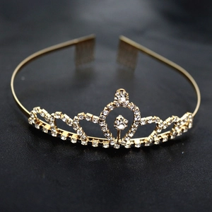 Détail macro du serre-tête couronne doré avec motifs de cœur et cristaux de strass brillants