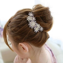 Detailed view of crystal floral hair comb with pearls styled on a bridal bun hairstyle