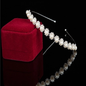Elegant pearl and rhinestone headband for women on a red velvet jewelry gift box