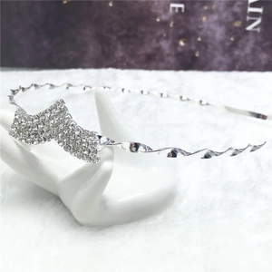 Serre-tête élégant en métal argenté torsadé avec strass brillants sur support en céramique