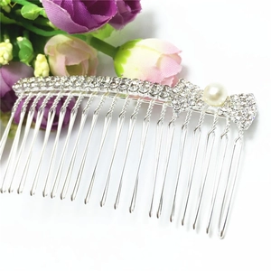 Elegant silver hair comb with crystal bow and white pearl accent on white background