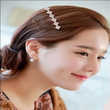 Detail of silver hair comb with rhinestones and pearl earrings on female model