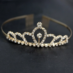 Détail d'une couronne en strass dorés scintillants avec motifs de cœurs et peignes latéraux