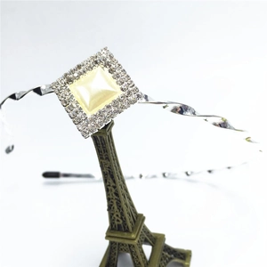 Serre-tête argenté torsadé avec perle carrée crème et strass sur support Tour Eiffel