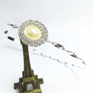Détail du serre-tête argenté avec fleur en perle et strass sur mini tour Eiffel