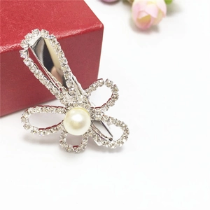 Detailed macro view of the silver flower hair clip with sparkling rhinestones and center pearl