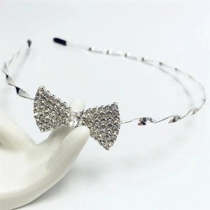 Détail du serre-tête argenté torsadé orné d'un nœud papillon en strass blancs brillants