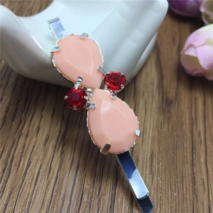 Détail de la pince à cheveux coréenne avec gemmes roses et strass rouges sur métal