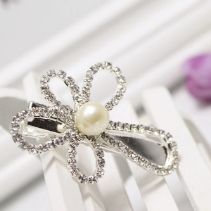 Elegant silver hairpin with rhinestone flower and faux pearl accent on white wood