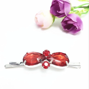 Barrette à cheveux élégante en argent avec cristaux rouges sur un fond blanc épuré