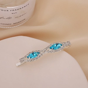 Détail de pince à cheveux argentée avec gemmes marquise bleu mer et strass blancs