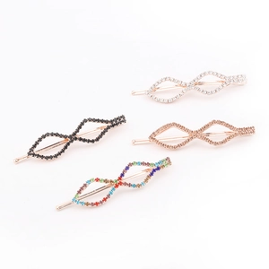 Detail of four crystal rhinestone hair clips in infinity shape and varied colors