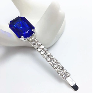Gros plan d'une barrette argentée avec zircon bleu profond et cristaux brillants