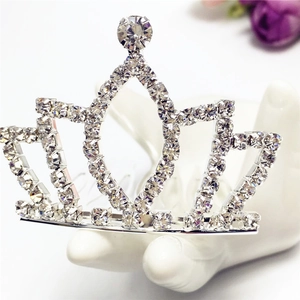 Close-up of silver crown hair comb with sparkling white rhinestones on hand display