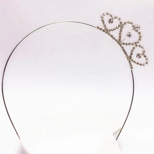 Detail of silver tiara showing three sparkling heart-shaped rhinestone patterns