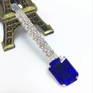 Barrette argentée ornée de trois rangées de zircons et d'une grande pierre bleue rectangulaire