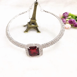 Détail d'un ras-de-cou à trois rangs de strass avec un grand pendentif rectangulaire rouge