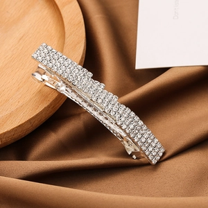 Silver barrette hair clip with rows of sparkling rhinestones on brown silk fabric