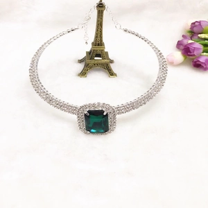 Détail du collier ras du cou en strass avec grosse pierre vert émeraude carrée