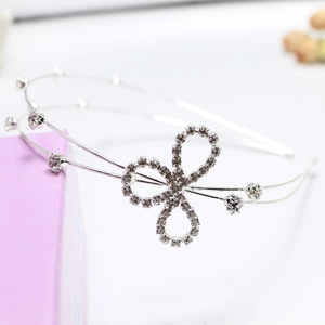 Macro detail of silver double-layer headband with sparkling rhinestone clover and crystals