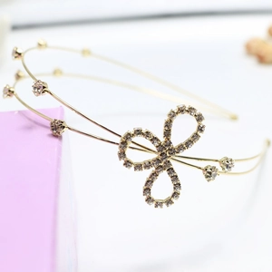 Close-up of golden metal headband with sparkling rhinestones and floral bow detail