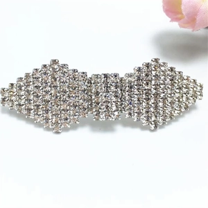 Detailed close-up of a silver-tone bow hair clip fully embellished with shiny rhinestones