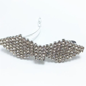Detailed close-up of sparkling rhinestone bow barrette hair clip with silver metal base