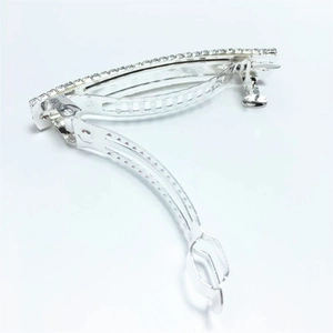 Detailed macro view of silver spring hair clip showing sparkling rhinestones and metal structure