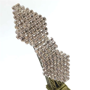 Detailed close-up of a luxury bow hair clip with sparkling rhinestones on a metal spring