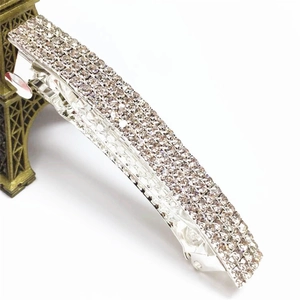 Macro detail of curved hair clip with four rows of sparkling rhinestones on silver base