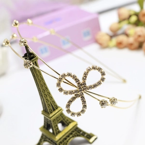 Detail of a double-layered gold rhinestone headband on an Eiffel Tower model stand