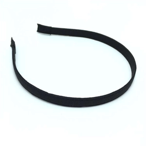Détail d'un serre-tête fin en tissu noir minimaliste sur un fond blanc neutre