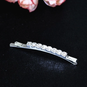 Détail d'une barrette argentée ornée de dix strass ronds scintillants sur une base en métal