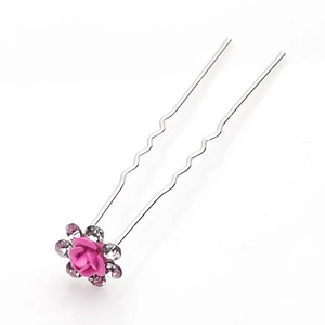 Dettaglio di forcina con rosa rosa, strass scintillanti e forcella a U in metallo ondulato