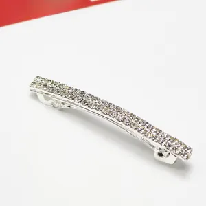 Dettaglio ravvicinato di un fermaglio argento con due file di strass trasparenti lucidi