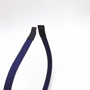 Détail de l'extrémité du serre-tête en tissu bleu foncé enveloppée d'un ruban noir