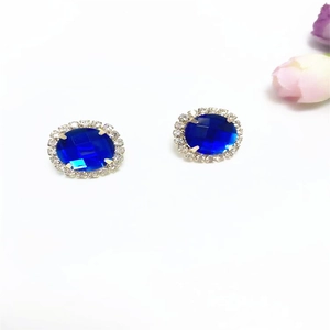 Detail of blue oval crystal earrings with sparkling silver diamond-encrusted edges