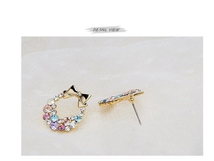 Macro detail of round wreath earrings with colorful rhinestones and a gold bow knot