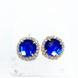 Elegant gold earrings with a large blue crystal surrounded by small white rhinestones