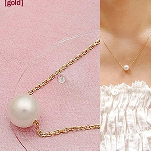 Collier minimaliste à perle unique avec fine chaîne dorée porté par un mannequin