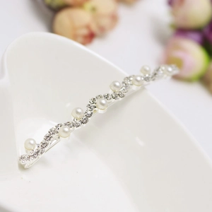 Détail d'une barrette à cheveux ondulée avec strass scintillants et perles blanches élégantes