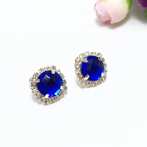 Boucles d'oreilles fleur dorées avec cristal bleu foncé et halo de strass blancs