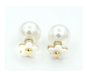 Detailed view of white flower stud earrings with a large white pearl backing design