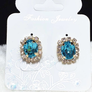 Classic blue oval crystal halo stud earrings with silver accents on display card